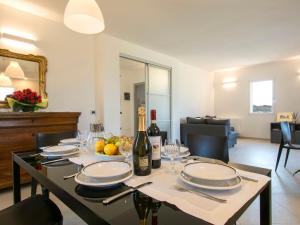 a dining room table with plates and a bottle of wine at Holiday Home La Rocchetta by Interhome in Montescudaio