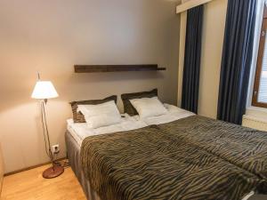 a bedroom with a bed and a lamp and a window at Holiday Home Ylläs chalets 2101 by Interhome in Ylläsjärvi