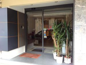 uma entrada para um edifício com dois vasos de plantas em Guest House Residence em Messina