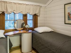 een slaapkamer met een bed, een spiegel en een raam bij Holiday Home Kotilampela by Interhome in Vuokatti