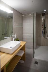 a bathroom with a white sink and a shower at Onar Superior Suites in Rethymno