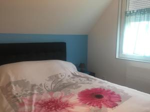 Un dormitorio con una cama con flores rosas. en Chez claudine, en Favières