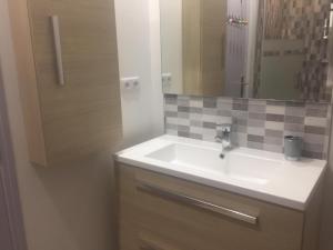 een badkamer met een witte wastafel en een spiegel bij Chez claudine in Favières