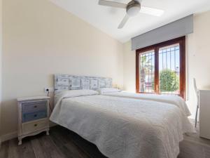 a white bedroom with a bed and a window at Holiday Home Aeris by Interhome in Cunit