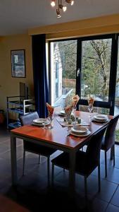 a dining room table with chairs and a large window at DURBUY RESIDENCE -A201- in Durbuy