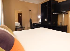 Habitación de hotel con cama y escritorio en Ribera Sur Hotel en Buenos Aires