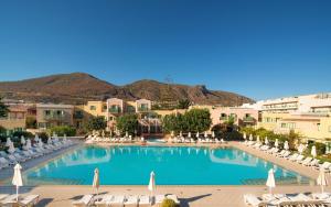 a large swimming pool with lounge chairs and umbrellas at Silva Beach Hotel in Hersonissos