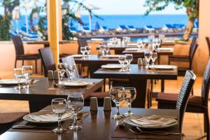 a restaurant with tables and chairs with wine glasses at Silva Beach Hotel in Hersonissos