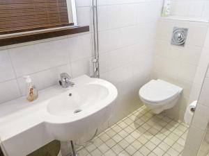 une salle de bain blanche avec un lavabo et des toilettes dans l'établissement Holiday Home Tahko spa suites orange a 8 by Interhome, à Tahkovuori
