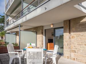 a patio with a table and chairs and a balcony at Apartment Résidence Villa Cassandre by Interhome in Quiberon