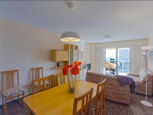 une cuisine et un salon avec une table en bois avec des fleurs dessus dans l'établissement Apartment Ana by Interhome, à Cullera