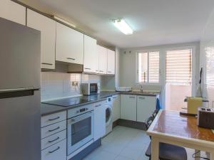 une cuisine avec des armoires blanches et une laveuse et une sécheuse dans l'établissement Apartment Ana by Interhome, à Cullera
