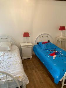 1 dormitorio con 2 camas y 2 mesitas de noche en les landes, en Plouër-sur-Rance