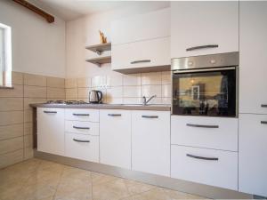 a kitchen with white cabinets and a sink at Holiday Home Saulja by Interhome in Sveti Juraj