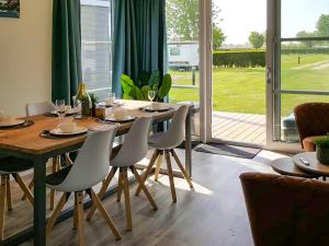 comedor con mesa, sillas y ventana en Holiday Home Camping Cassandria Bad-1 by Interhome, en Retranchement