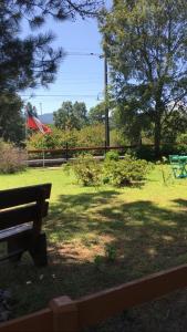 un parque con un banco y una bandera en el césped en Cabañas Trabunco, en Pucón