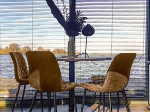 a table and chairs with a table and a window at Holiday Home De Meerparel-1 by Interhome in Uitgeest