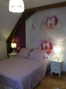 een slaapkamer met een bed met bloemen aan de muur bij Au Temps Retrouvé in Courcelles