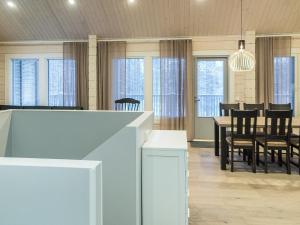 comedor con mesa, sillas y ventanas en Holiday Home Villa kero by Interhome, en Äkäslompolo