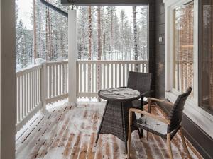 un porche con mesa, sillas y árboles nevados en Holiday Home Villa kero by Interhome, en Äkäslompolo