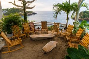 un gruppo di sedie e una panchina sulla spiaggia di Hotel Pasión de Luna a Puerto Ángel