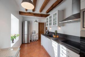 a kitchen with white cabinets and a stainless steel refrigerator at Au Temps Retrouvé in Courcelles