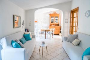 een woonkamer met 2 banken en een tafel bij Da Fe' - Casa con terrazza panoramica in Cuglieri