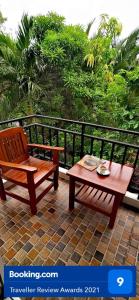 eine Holzbank und einen Tisch auf dem Balkon in der Unterkunft Baan Glangsuan Bang Kobua in Bang Chak