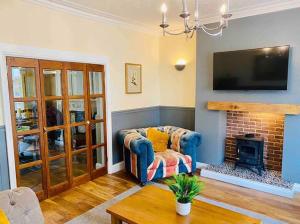 a living room with a couch and a fireplace at Coastguard House in Woodhorn