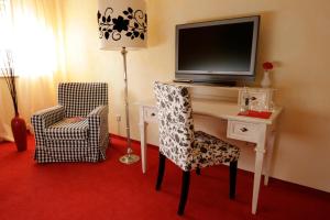 a room with a desk with a television and a chair at Hotel Villa Verde in Düsseldorf