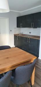eine Küche mit einem Holztisch und schwarzen Schränken in der Unterkunft Ferienwohnung Werraglück in Eschwege