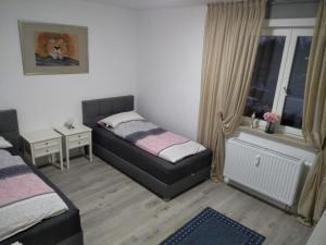 a small bedroom with two beds and a window at Ferienwohnung in Birkenwerder mit Balkon in Birkenwerder
