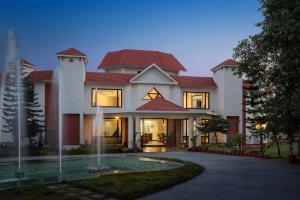 Naturoville Resort في Doiwāla: منزل كبير أمامه ممر