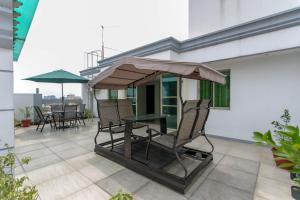 a patio with chairs and a table with an umbrella at Starlight Bed and Breakfast in Manila