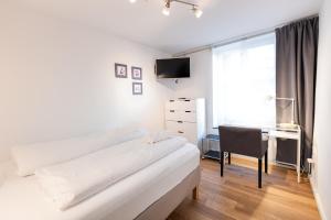 a white bedroom with a bed and a desk at Elisabeth Apartments in Marburg an der Lahn