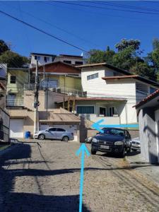 une rue avec deux voitures garées dans un parking dans l'établissement Cantinho Suico Aluguel de Temporada, à Nova Friburgo