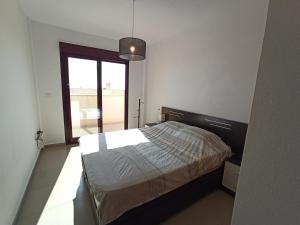 - une chambre avec un lit et une grande fenêtre dans l'établissement Modern apartment with large terrace in Mojon Hills, à Carthagène