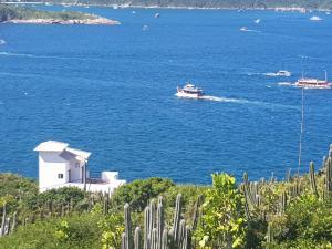 a boat in the water next to a lighthouse at Casa Corazul in Arraial do Cabo