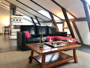 サント・マリー・オー・ミーヌにあるLa Clé d'Alsaceのリビングルーム(黒い革張りのソファ、テーブル付)