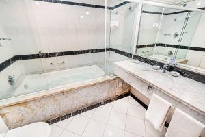 a bathroom with a tub, toilet and sink at Euro Suite Campinas in Campinas