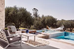 un patio con tavolo e sedie accanto alla piscina di Villa Carpos a Chania