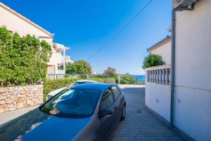 un coche azul estacionado al lado de un edificio en Villa Mirjana, en Trogir