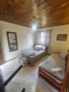 1 dormitorio con 2 camas y sofá en Hotel Praia Do Rosa, en Praia do Rosa