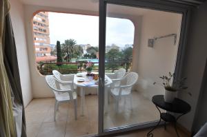 un balcon avec une table et des chaises blanches et une fenêtre dans l'établissement RNET - IR 27-B Studios Roses Costa Brava, à Roses
