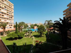une vue sur un parc avec des palmiers et une piscine dans l'établissement RNET - IR 27-B Studios Roses Costa Brava, à Roses