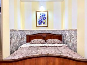 a bed in a room with a striped wall at ApartPoltava Французький шик у центрі Полтави, 4 спальних місця, Корпусний парк in Poltava
