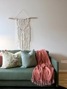 um sofá verde com almofadas e um cobertor em Oporto Serviced Apartments - Miragaia no Porto