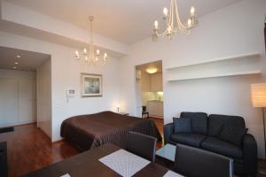 a bedroom with a bed and a couch and a table at Gella Serviced Apartments Office in Helsinki