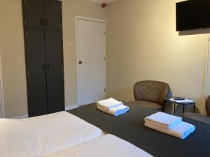ein Schlafzimmer mit einem Bett und zwei Handtüchern auf einem Tisch in der Unterkunft Hotel De Horper Wielen in Kaard