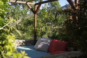 a bed with two pillows sitting under a pergola at La Clavelière in Saint-Auban-sur-Ouvèze